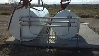 Two large white tanks are sitting on top of a concrete platform.