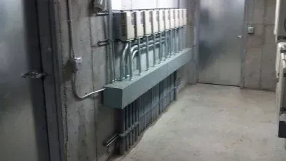 A hallway with a bunch of electrical wires hanging on the wall.