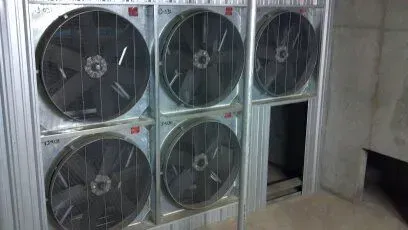 A row of fans are stacked on top of each other on a wall.