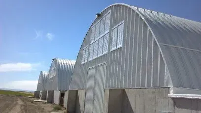 A row of arched buildings with a blue sky in the background.