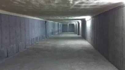 A long concrete tunnel with a light at the end of it.