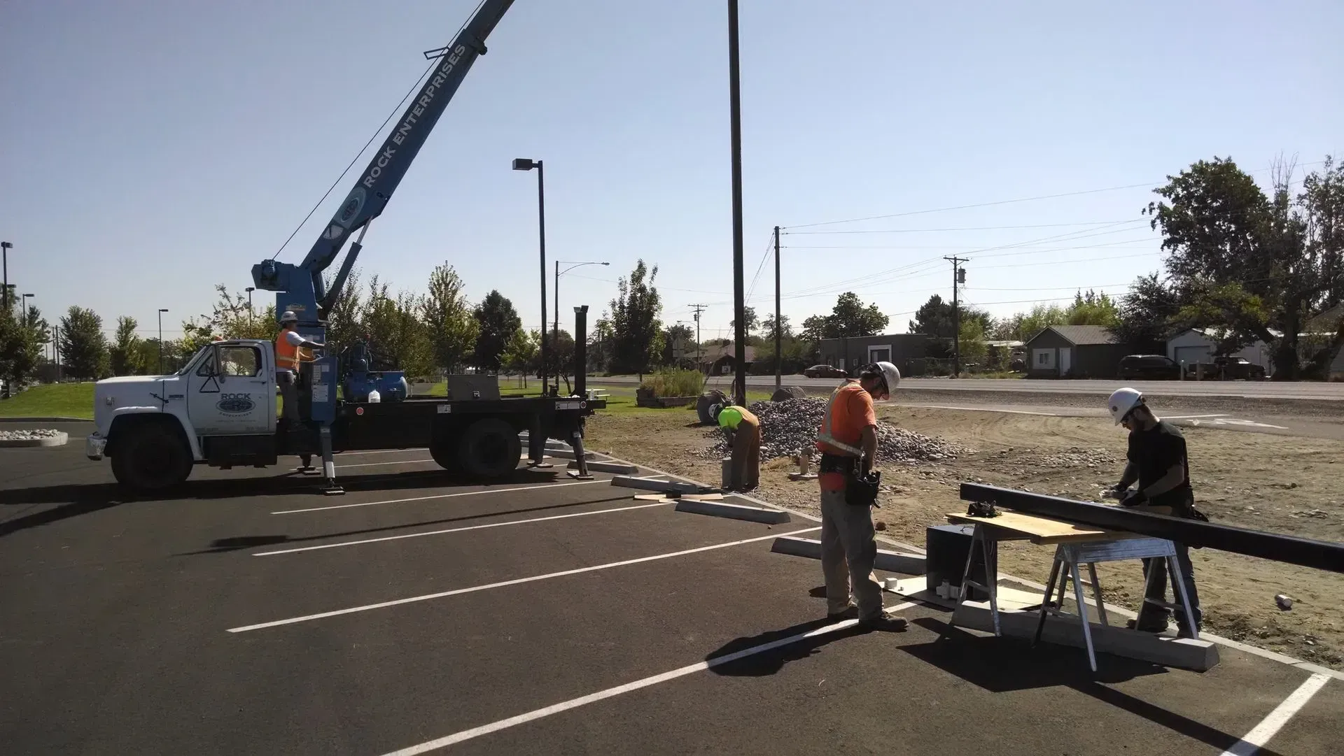 A white truck with a crane on the back is parked in a parking lot