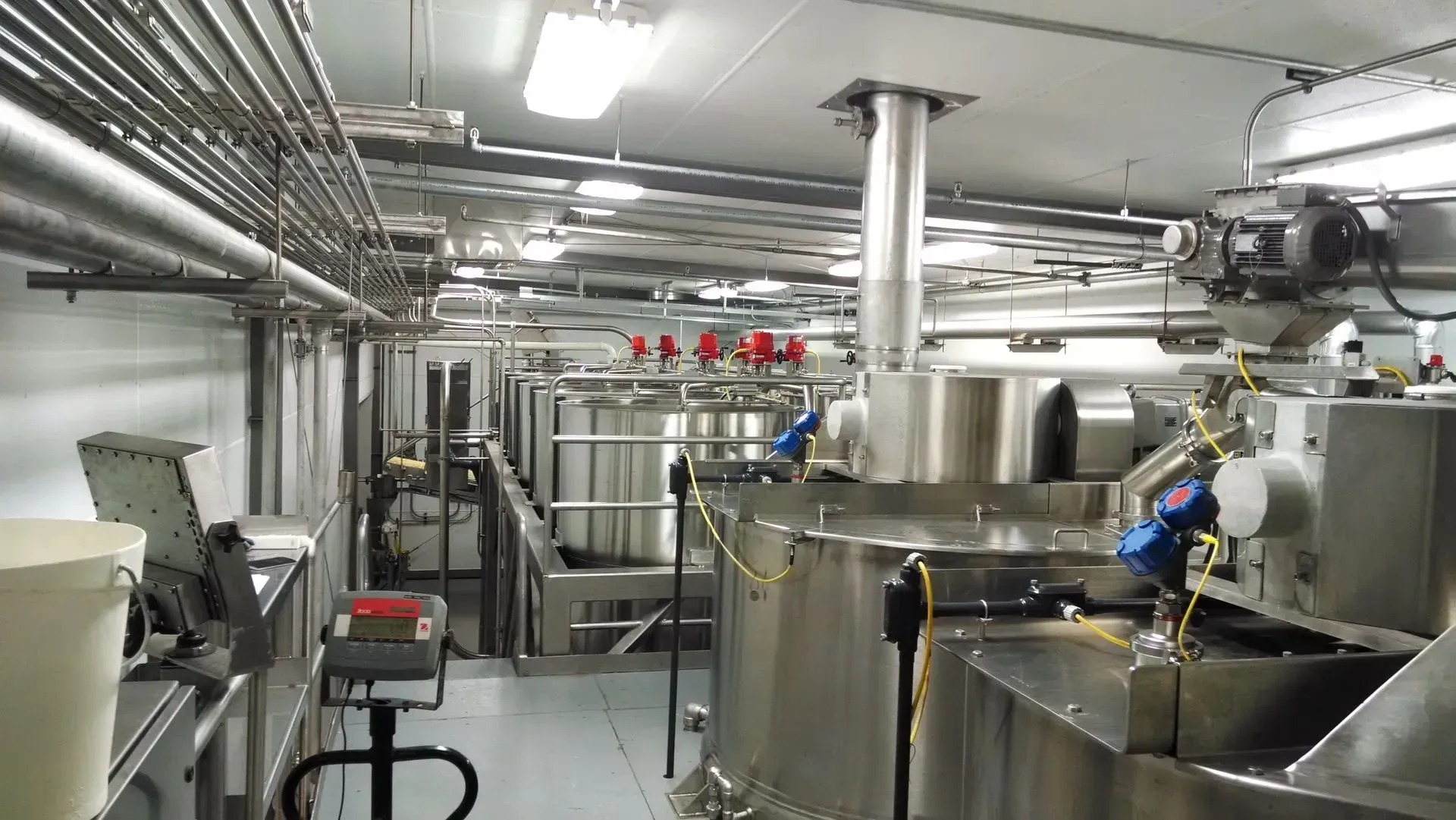 A large room filled with lots of stainless steel appliances and pipes.