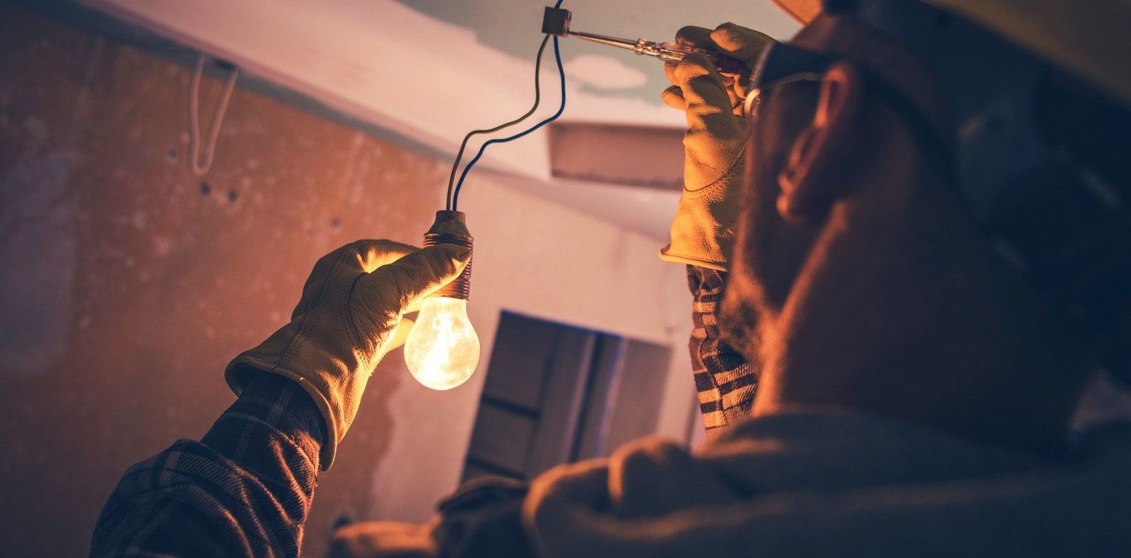 A man is holding a light bulb in his hand.