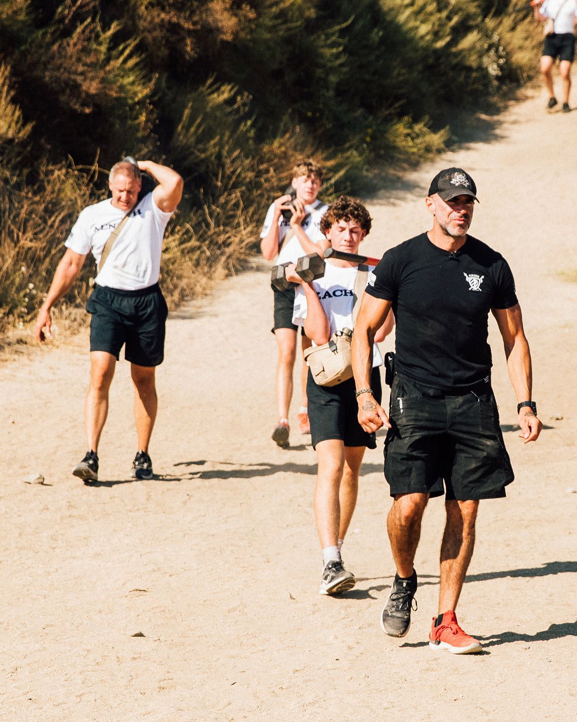 A group of people are walking down a dirt road