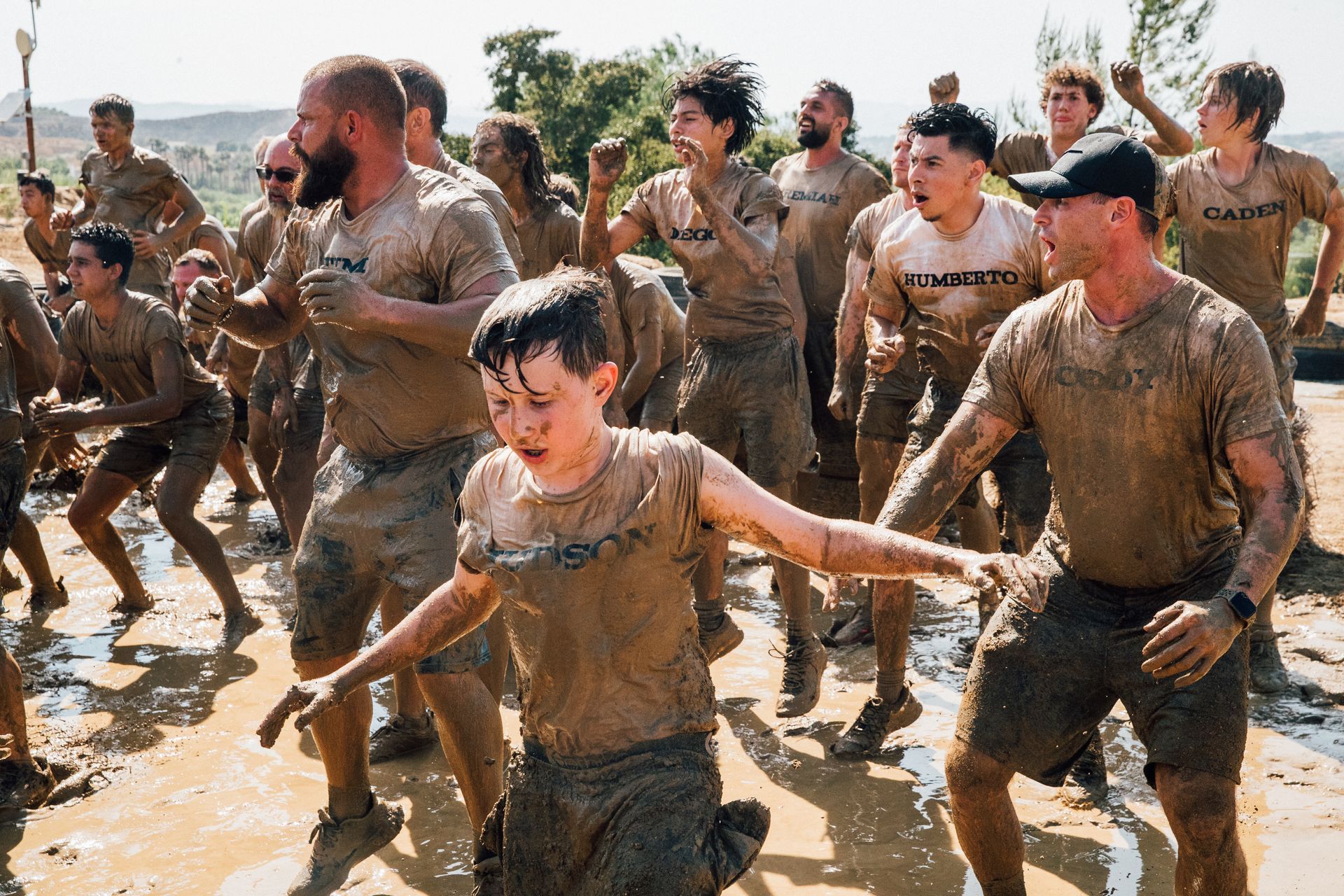 A group of people are standing in the mud.