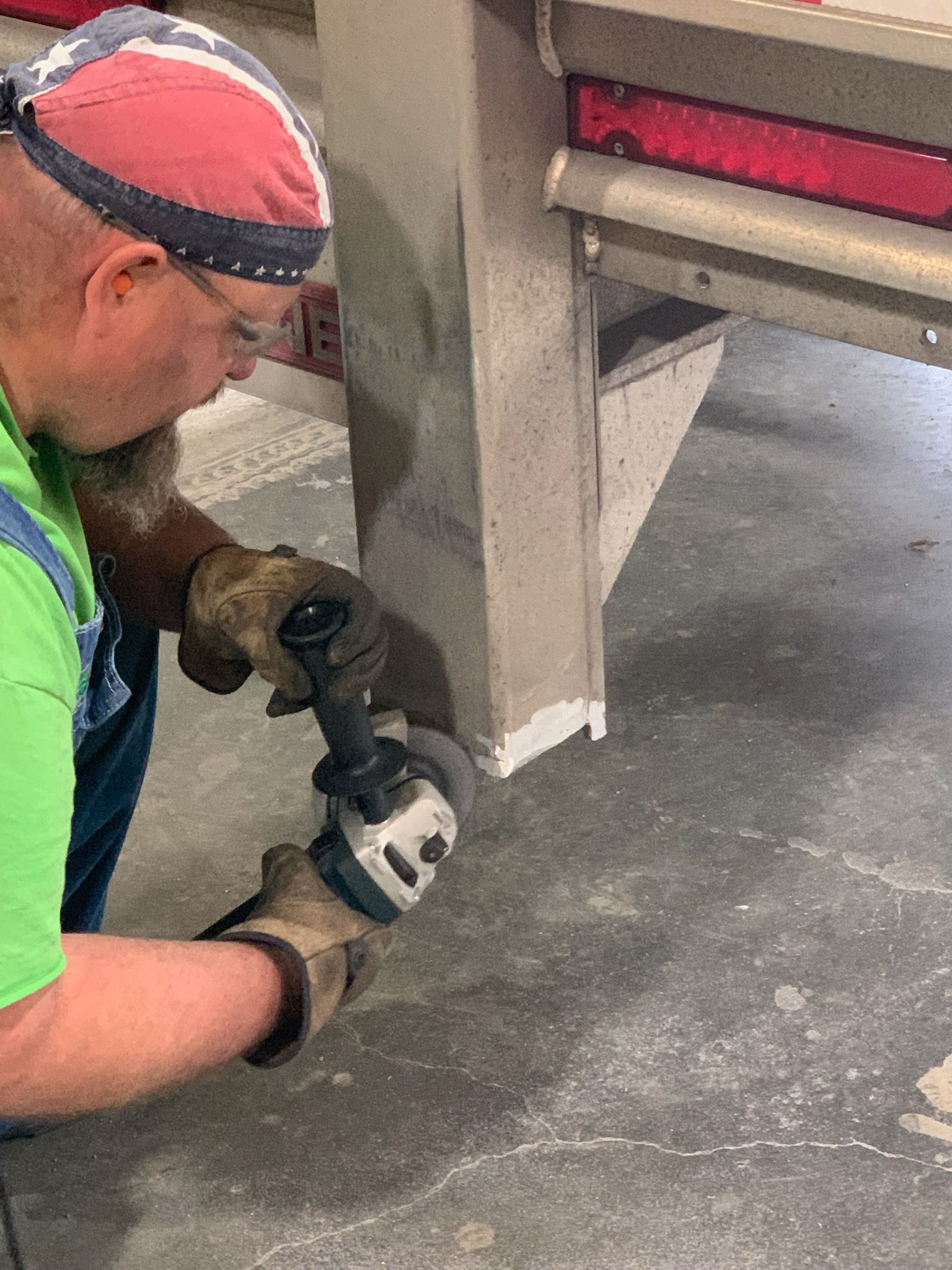 A man is welding a piece of metal in a dark room