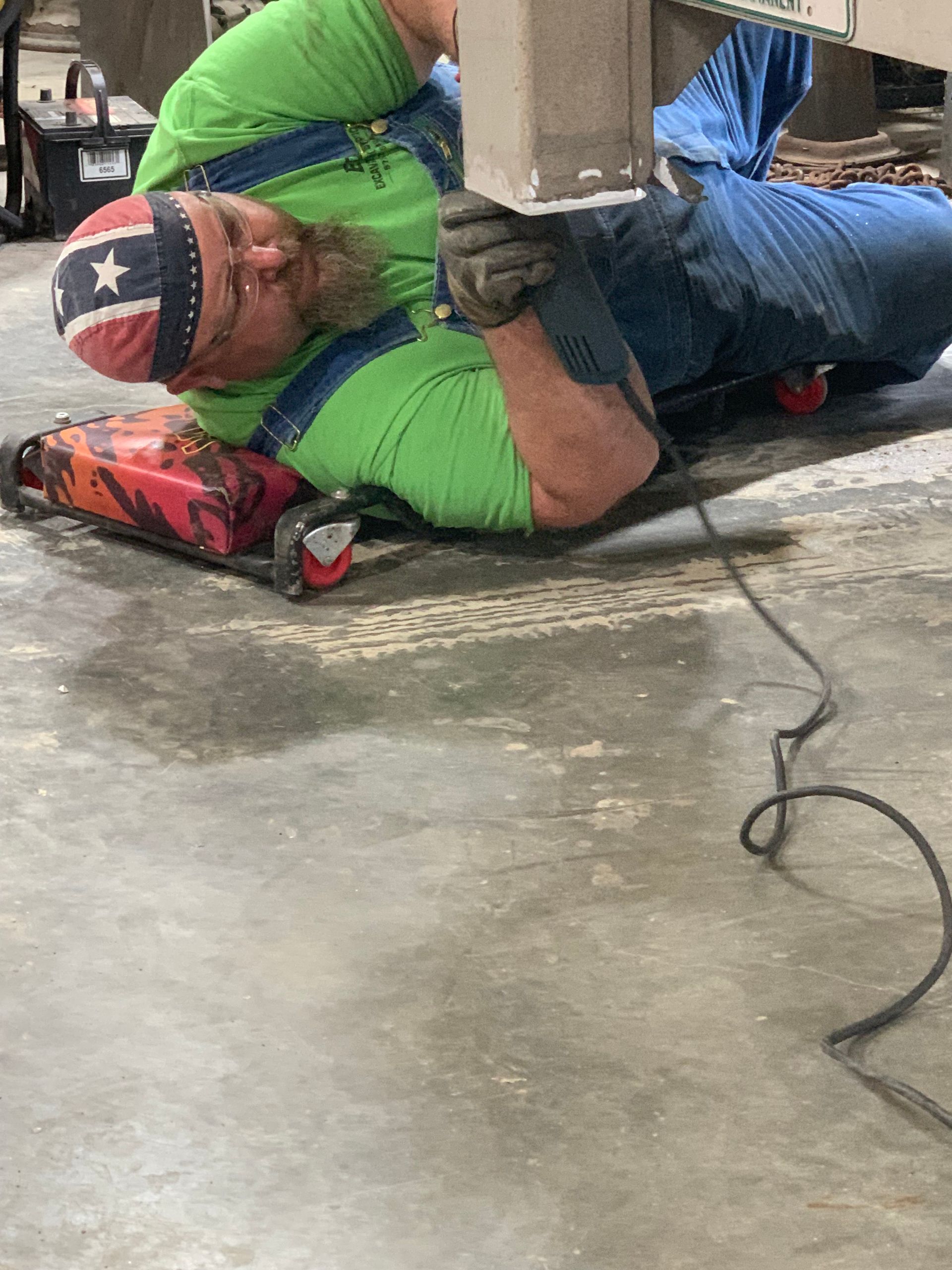 A man is welding a piece of metal in a dark room