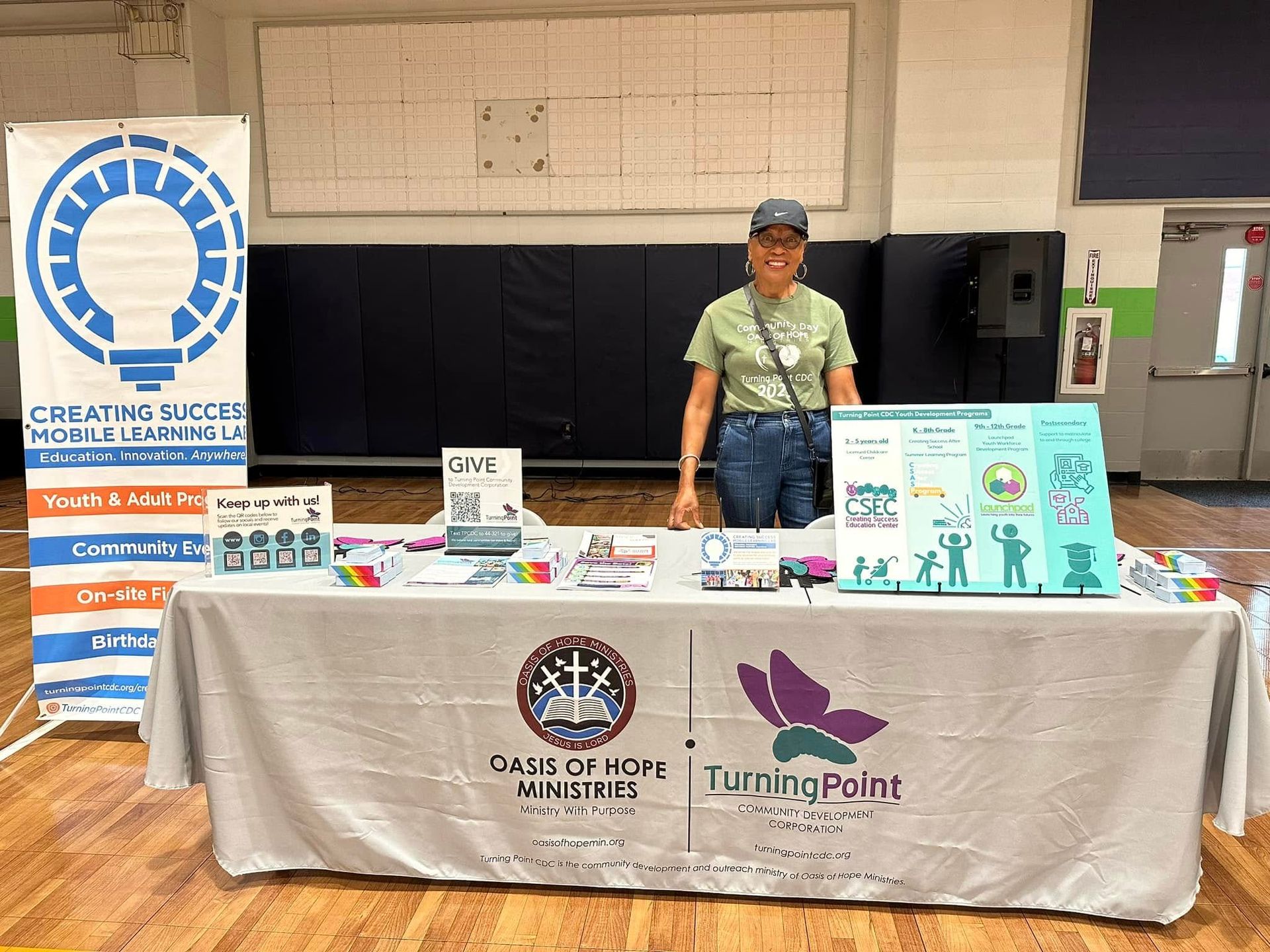 A woman is standing in front of a table with a white table cloth.