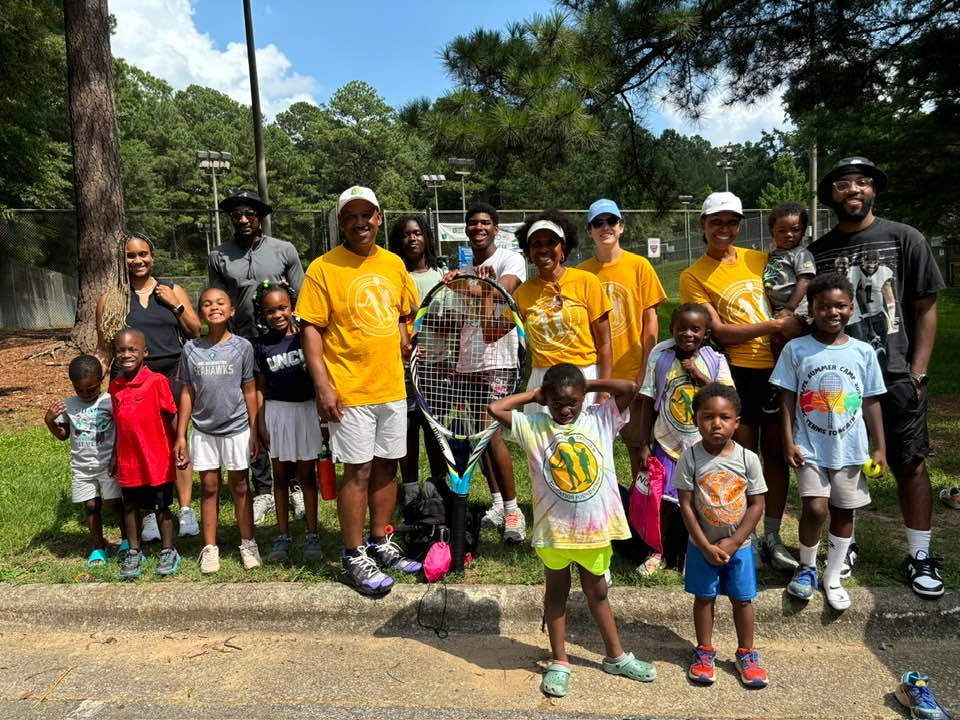 A group of people are posing for a picture in a park.