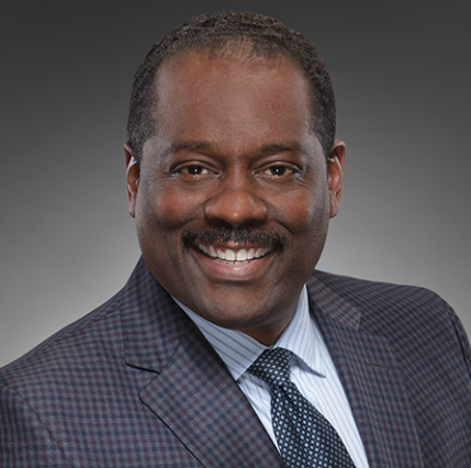 A man in a suit and tie is smiling for the camera.