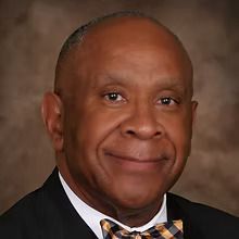 A man in a suit and bow tie is smiling for the camera.