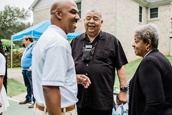 A group of people are standing outside of a building talking to each other.