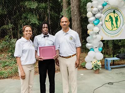 A group of people standing next to each other on a tennis court holding a certificate.