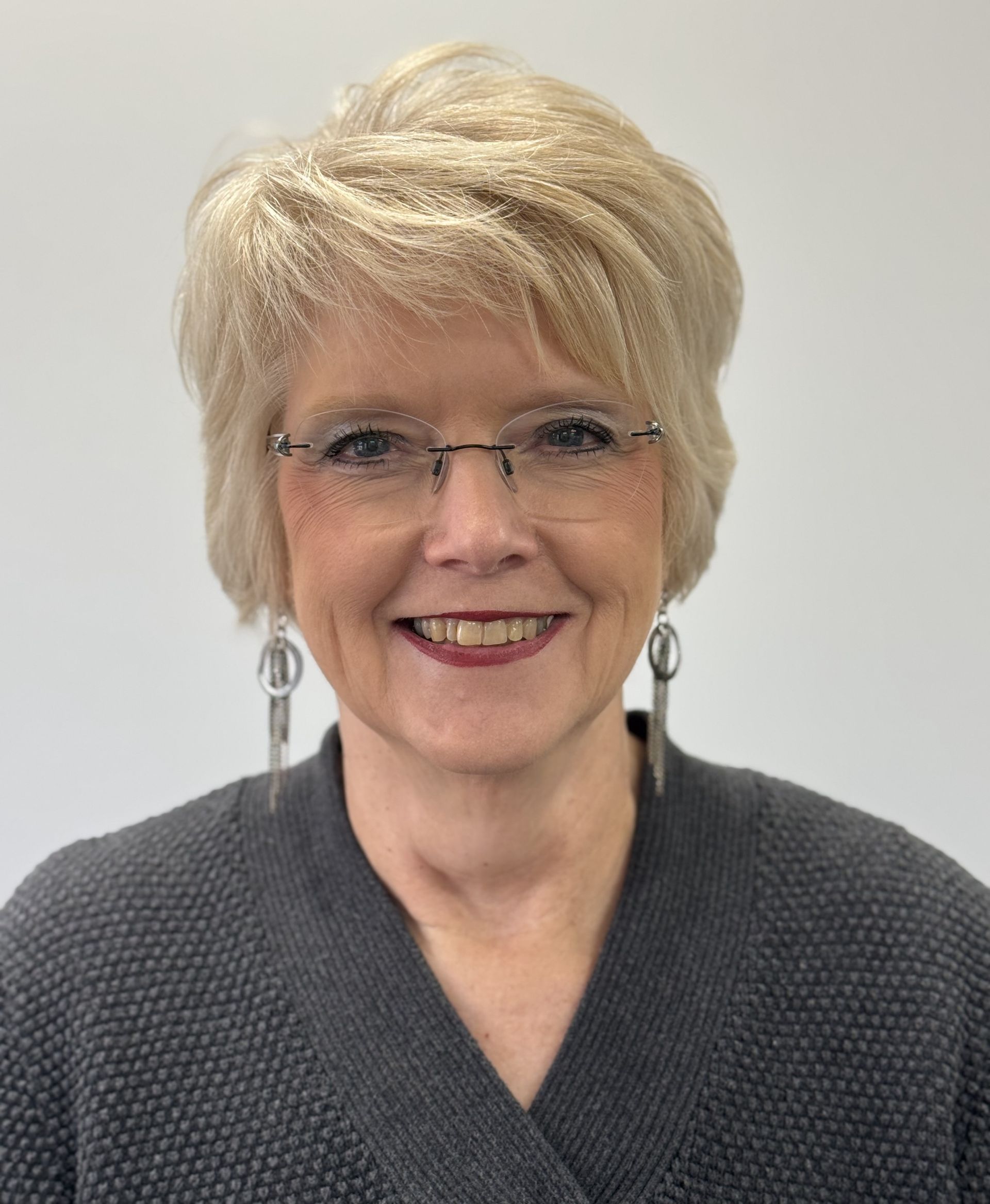 A woman stands in front of a display of glasses