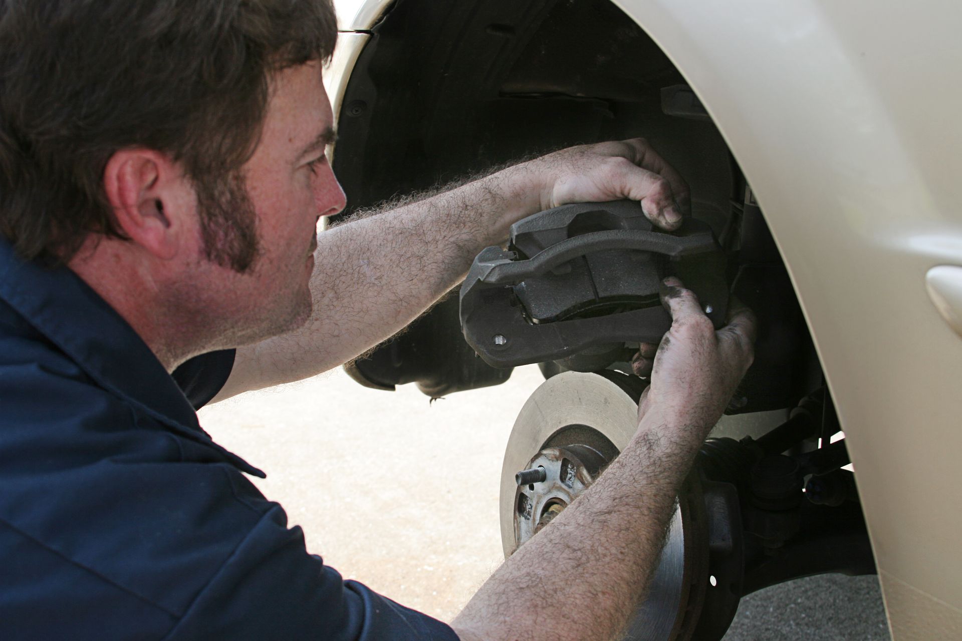 A technician is working at a brake repair shop repairing the brake system of a vehicle.
