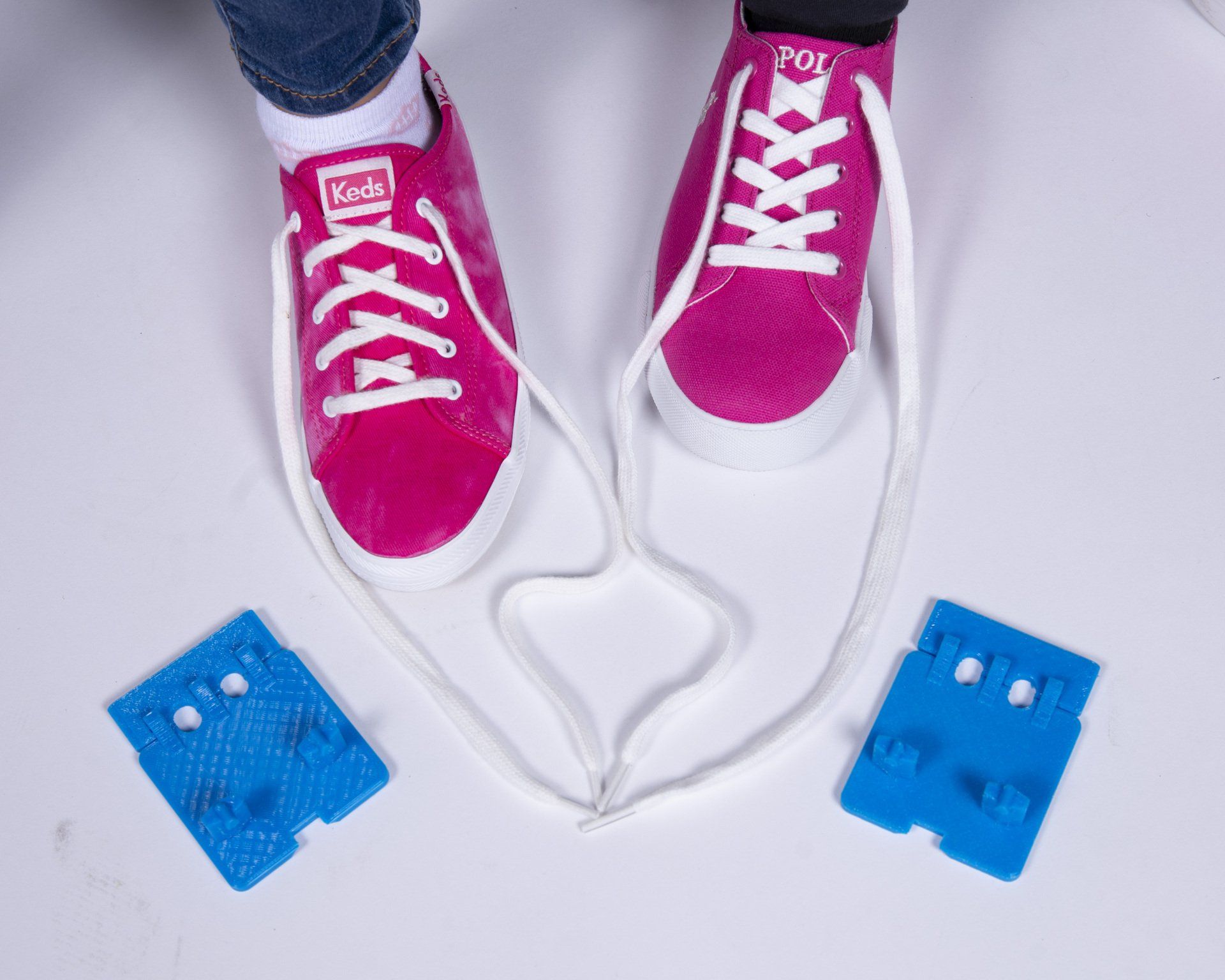 A pair of pink keds shoes with white laces
