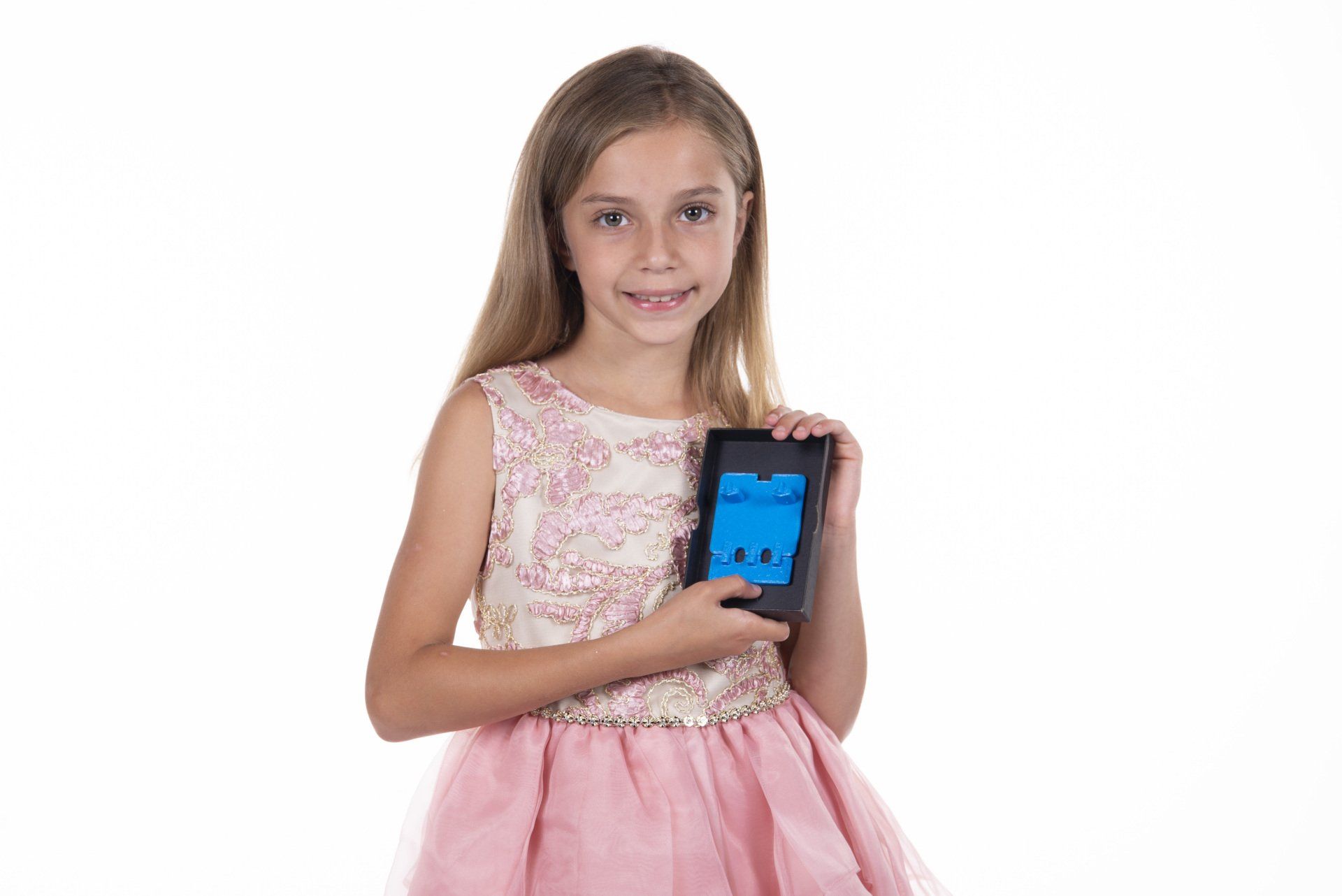 A little girl in a pink dress is holding a tablet computer.