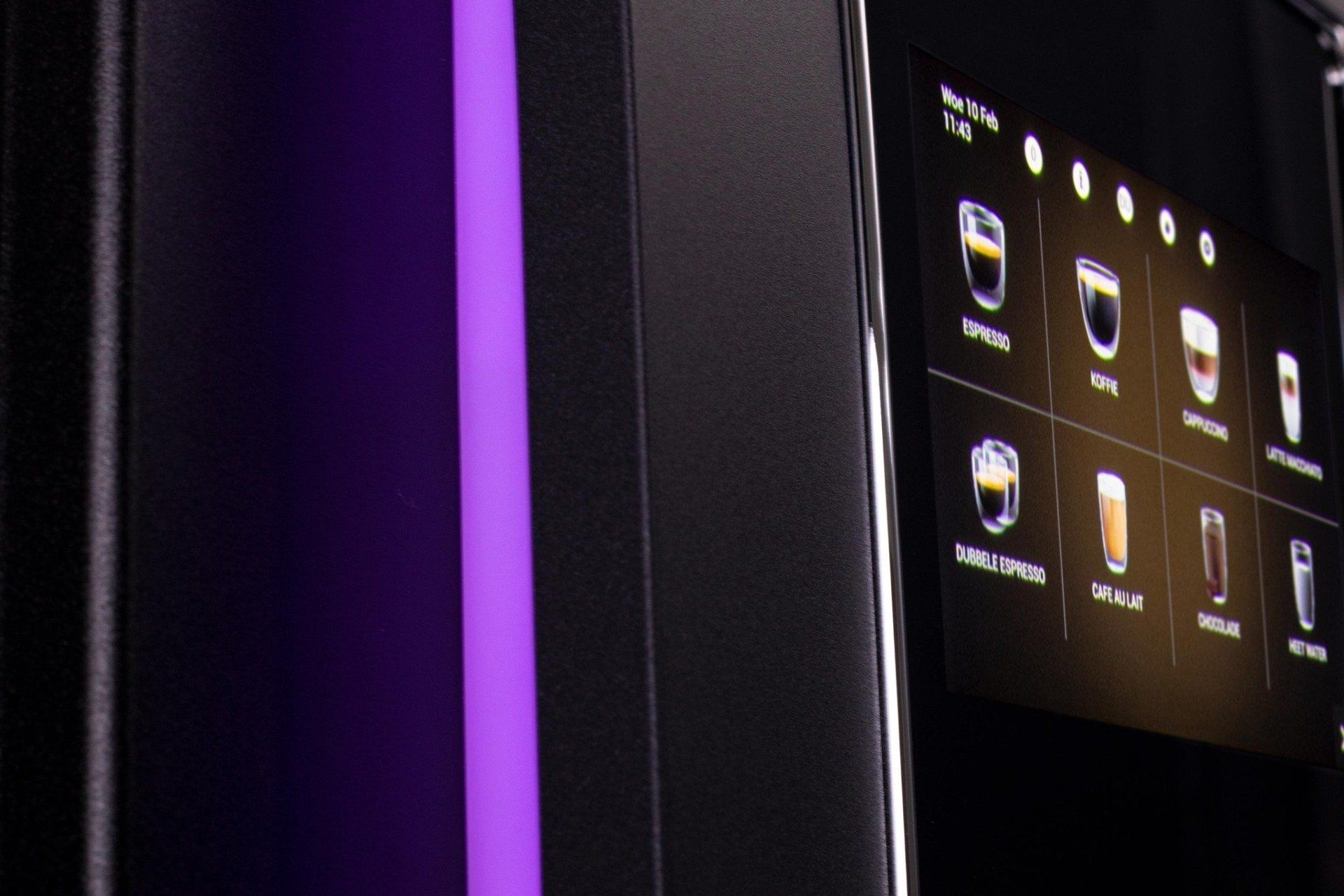Koffiemachine met touchscreen, waarop verschillende drankopties worden weergegeven. Paarse streep aan de zijkant.
