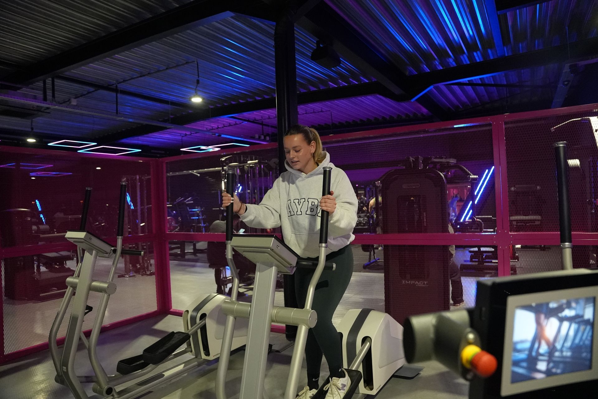 Een vrouw rijdt op een crosstrainer in een sportschool.