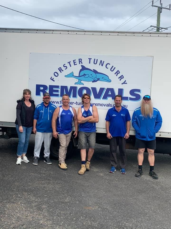 A Group of People Pose in Front of a Forster Tuncurry Removals Truck — Forster Tuncurry Removals & Storage in Sydney, NSW