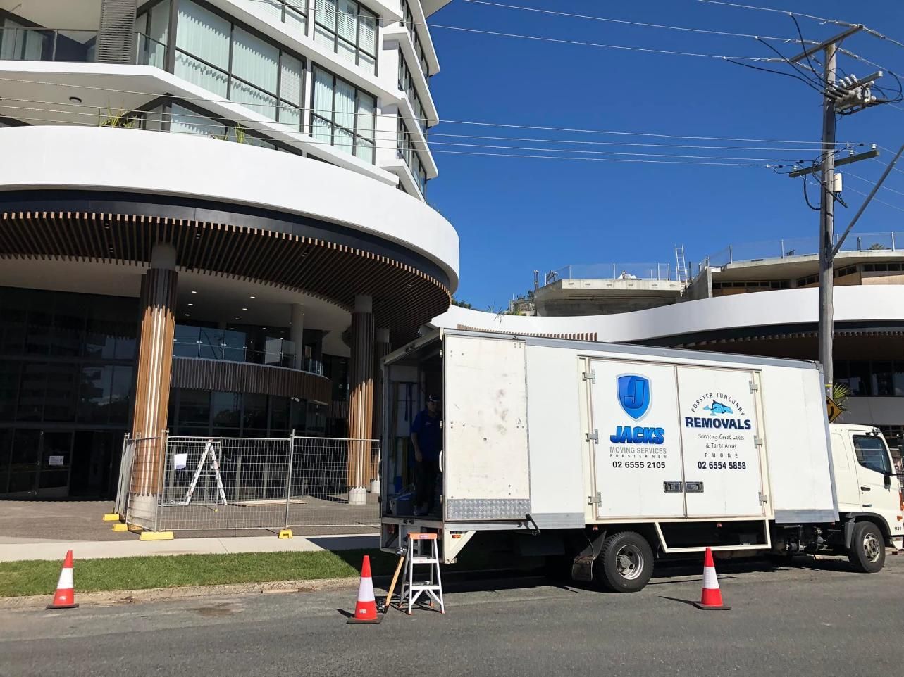 White Truck Parked Outside a Modern Building — Forster Tuncurry Removals & Storage in Forster, NSW