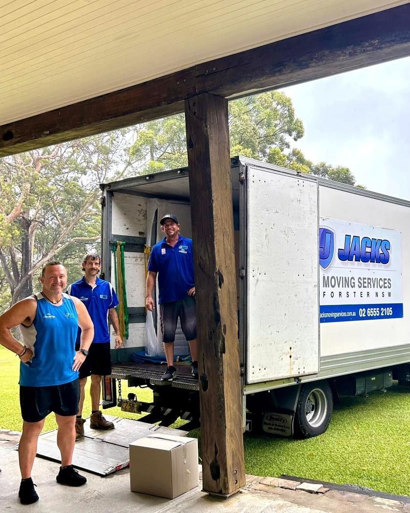 Three Movers Loading a Truck Under a Porch — Forster Tuncurry Removals & Storage in Forster, NSW