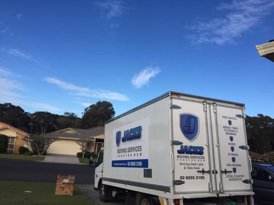 A White Moving Truck is Parked in Front of a House — Forster Tuncurry Removals & Storage in Tuncurry, NSW
