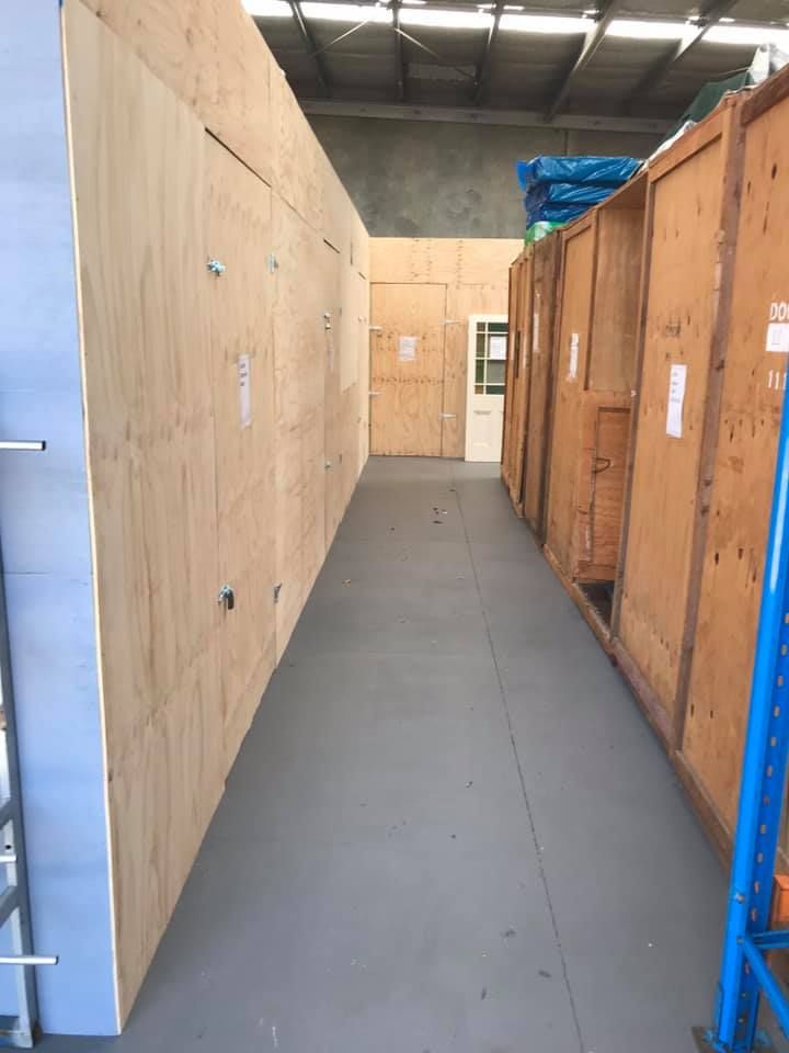 A Long Hallway Filled With Wooden Boxes in a Warehouse — Forster Tuncurry Removals & Storage in Tuncurry, NSW