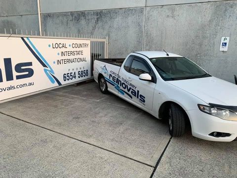 A White Truck is Parked Next to a Sign That Says Removals — Forster Tuncurry Removals & Storage in Tuncurry, NSW 