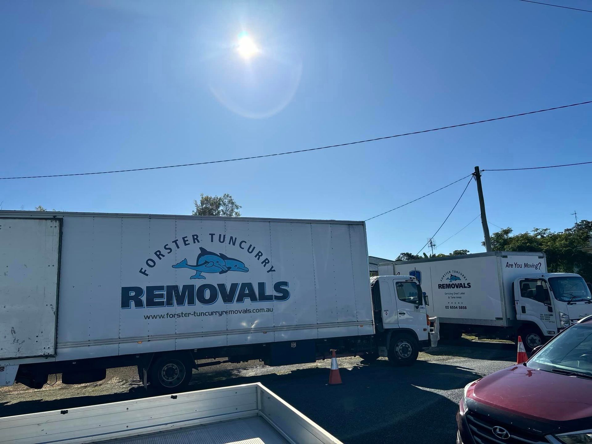 Two Removal Trucks Are Parked Next to Each Other in a Parking Lot — Forster Tuncurry Removals & Storage in Tuncurry, NSW