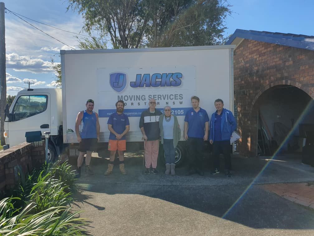A Group of People Standing in Front of a Moving Truck — Forster Tuncurry Removals & Storage in Tuncurry, NSW