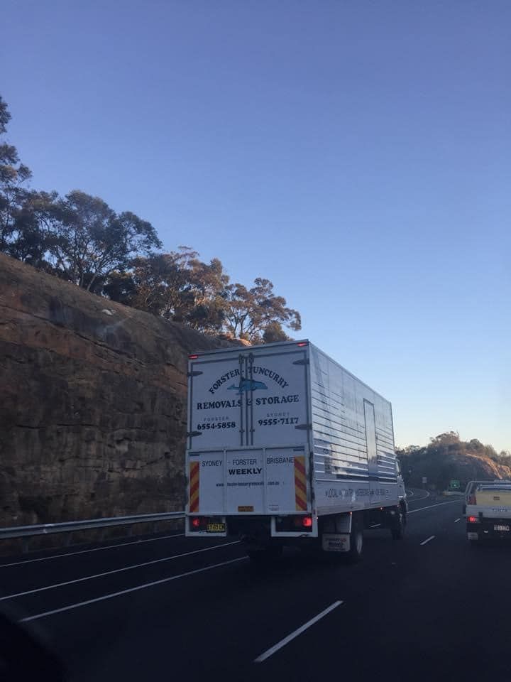 A Large White Truck is Driving Down a Highway — Forster Tuncurry Removals & Storage in Tuncurry, NSW