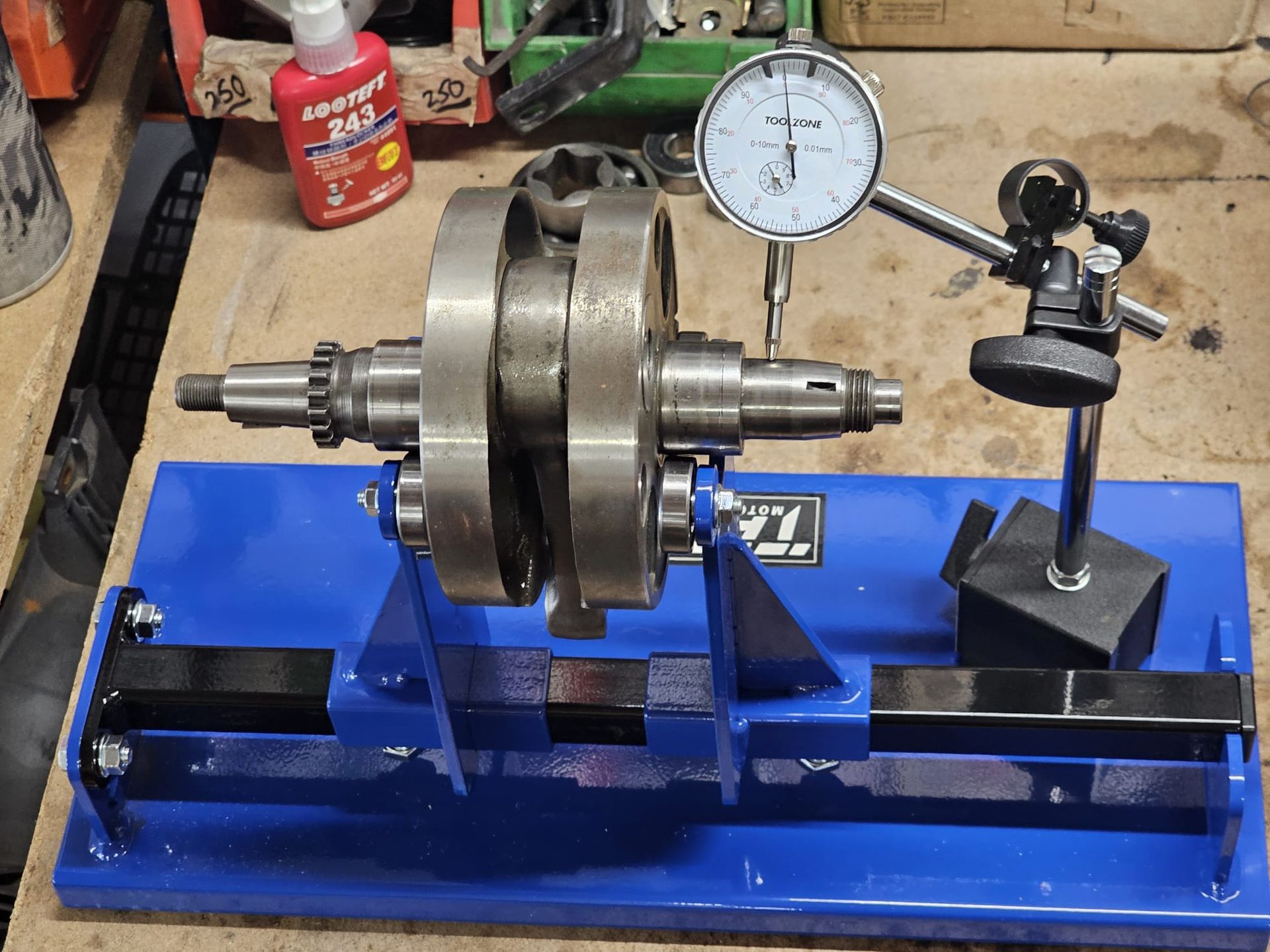 A person measures the diameter of a cylindrical metal object with digital calipers in a workshop. The reading is 62.72.