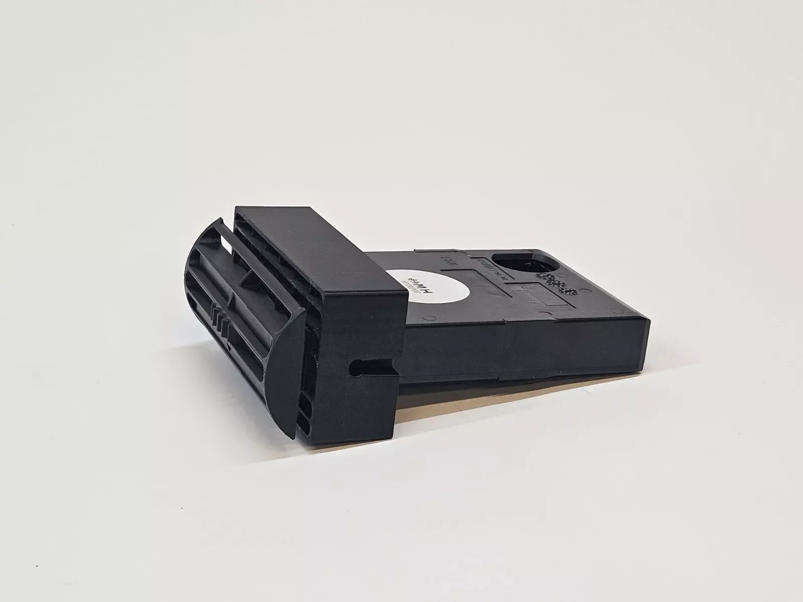 Black plastic device with rectangular and ridged sections.
