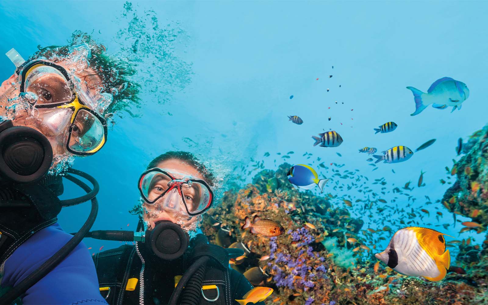 A man and a woman are taking a selfie in the ocean.