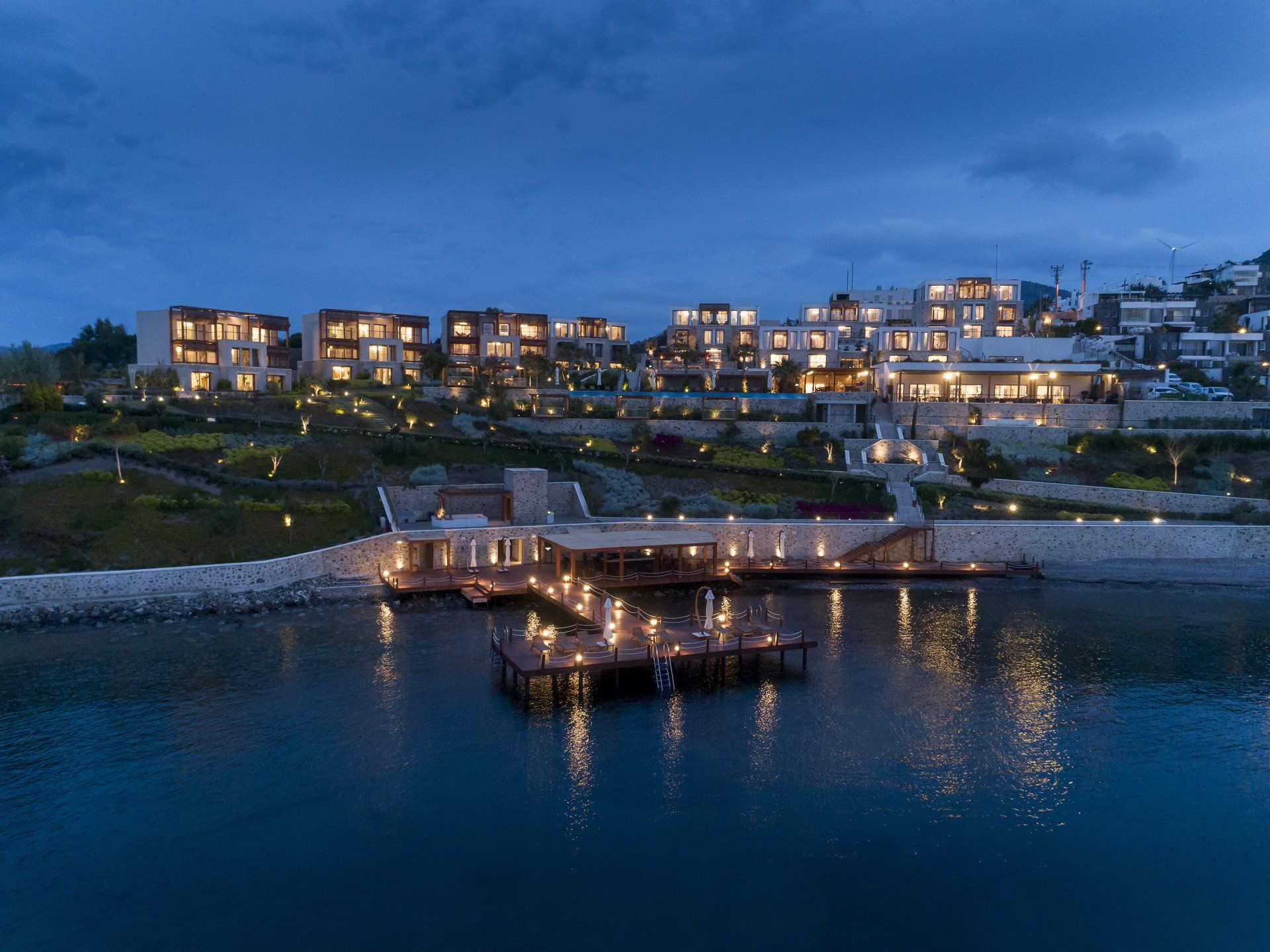 An aerial view of a hotel surrounded by water at night.