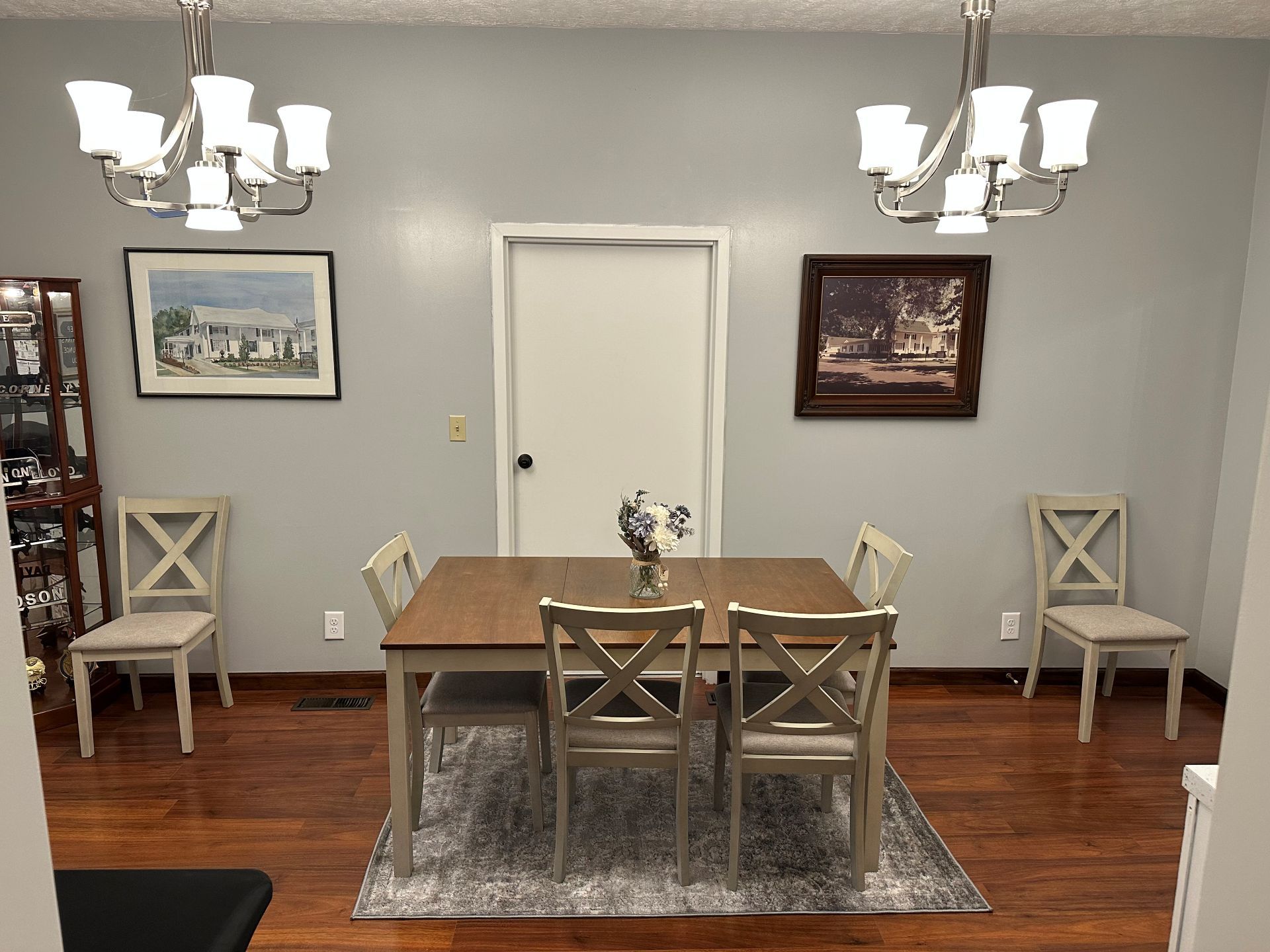 A dining room with a table and chairs and a chandelier.