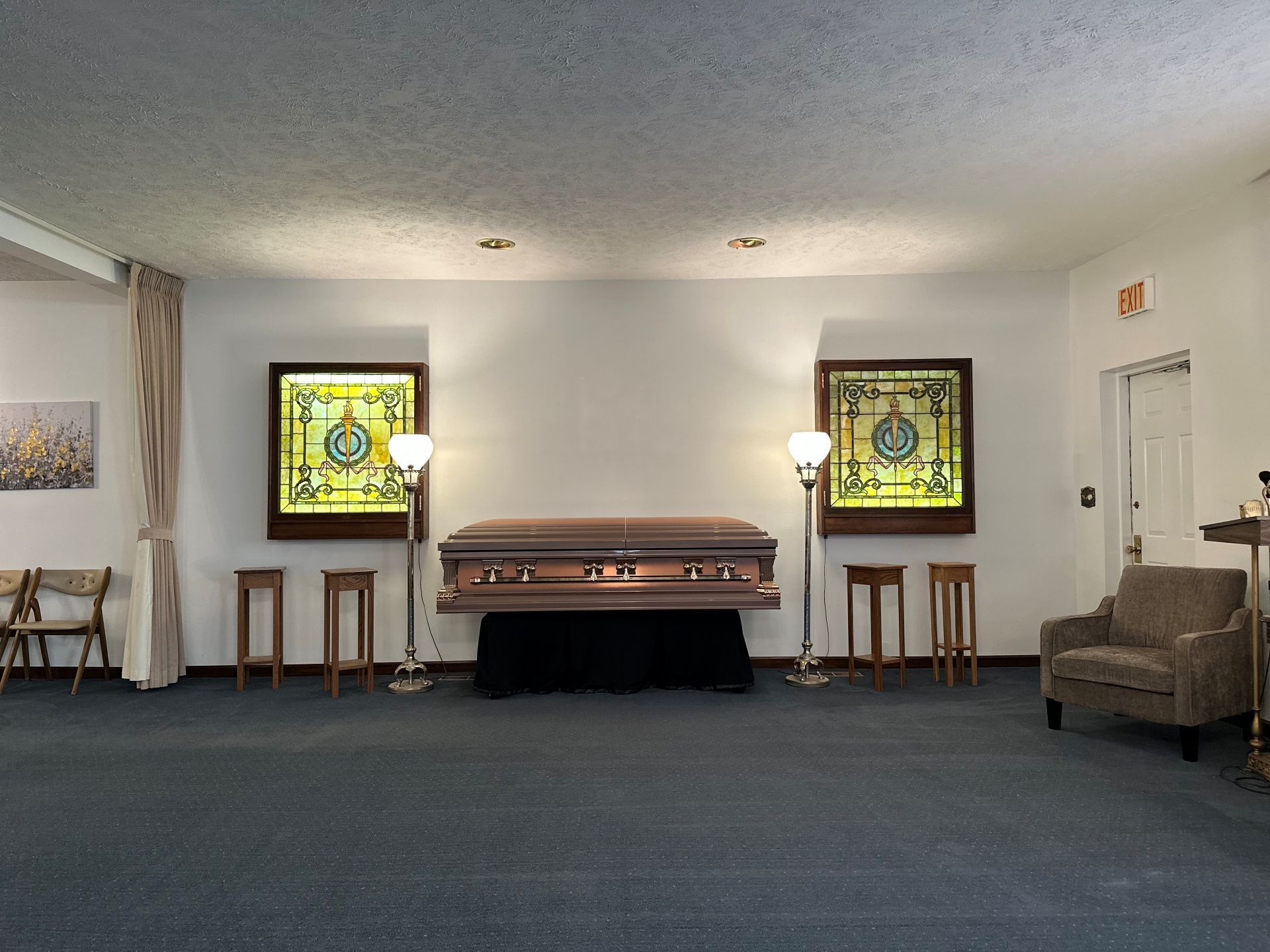 A room with a coffin and stained glass windows