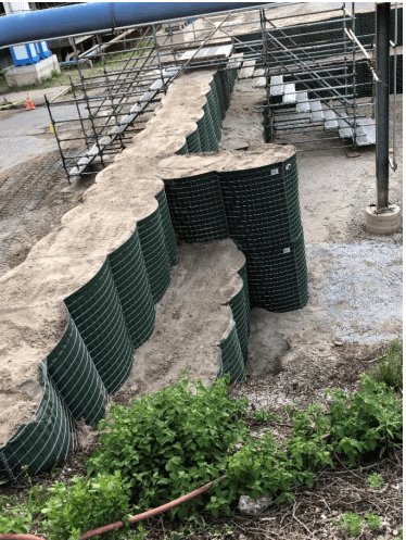 HESCO Barrier buttress wall example done by attaching a couple cells of the existing floodwall at a 90 degree angle. This is a simple method to reinforce your flood barrier as desired