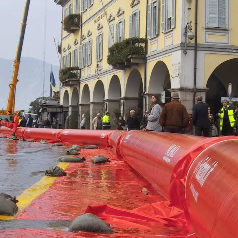 The NOAQ Tubewall is an air filled flood barrier that is anchored by the incoming floodwater as it sits on the ground skirt attached to the inflatable flood barrier tube.  Long sections of this barrier can be linked together and filled from a single source.
