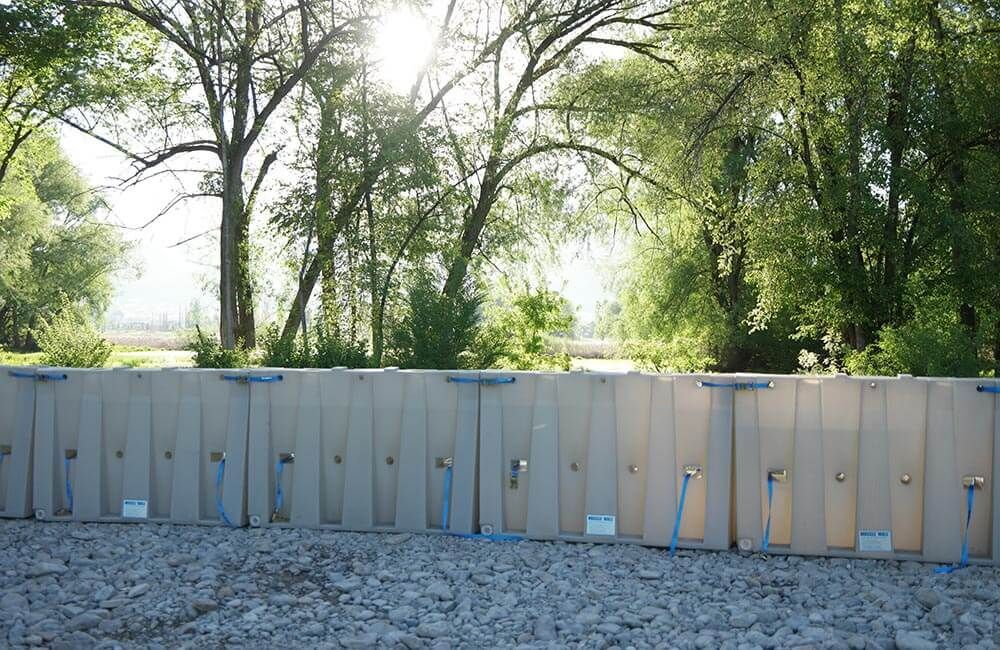 Water filled flood barrier being constructed.