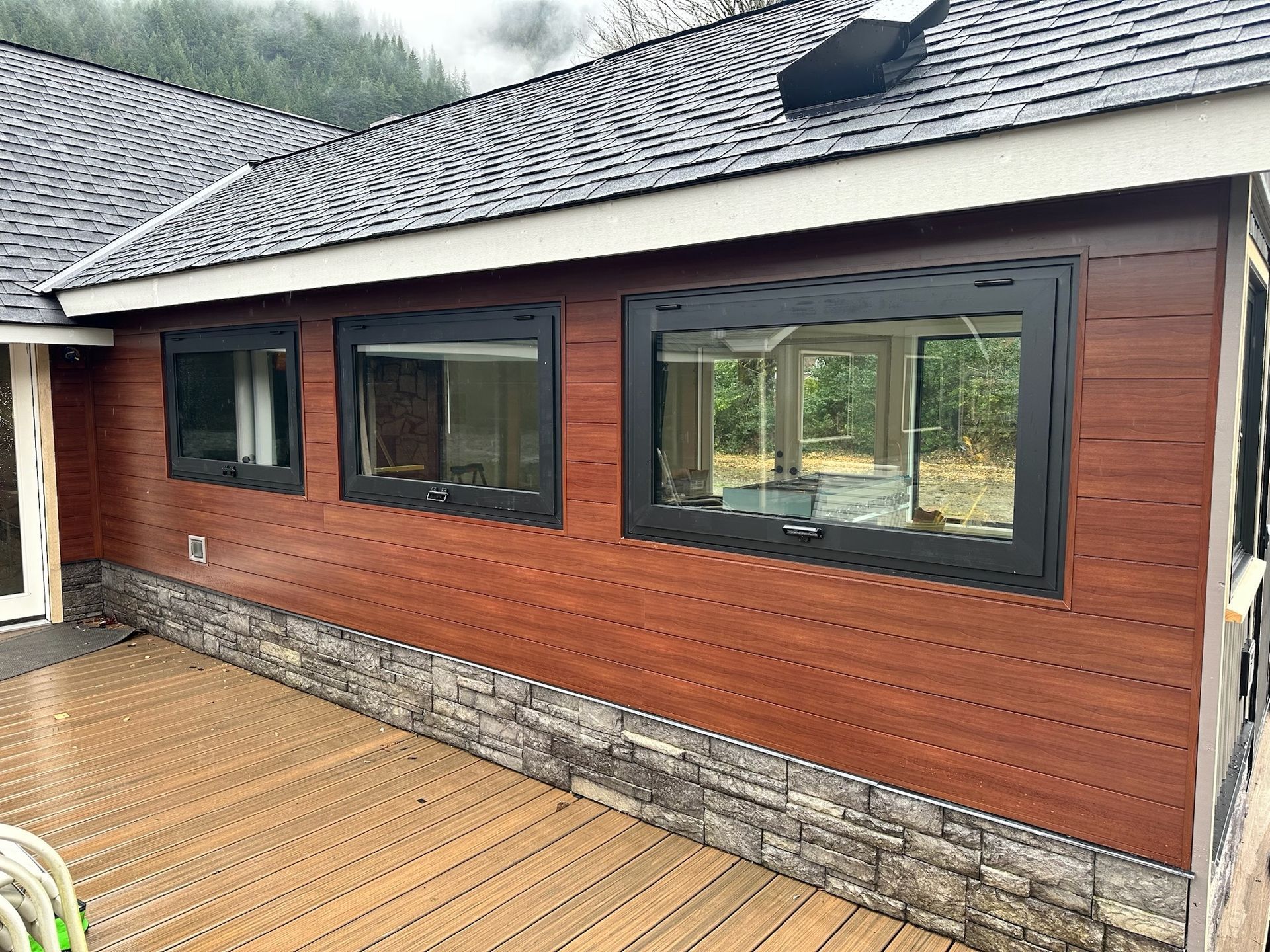 A bathroom with a white vanity, a toilet, and gray tiled flooring, viewed from above near a bathtub.
