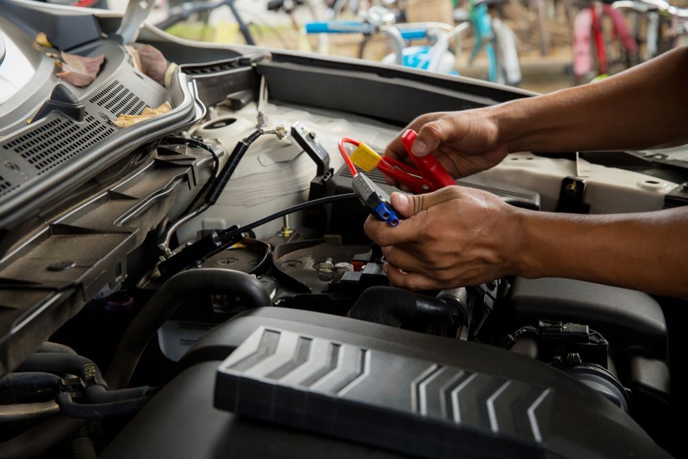 A Person is Holding a Screwdriver Over a Car Battery — Edmonton Battery Centre In Bentley Park, QLD