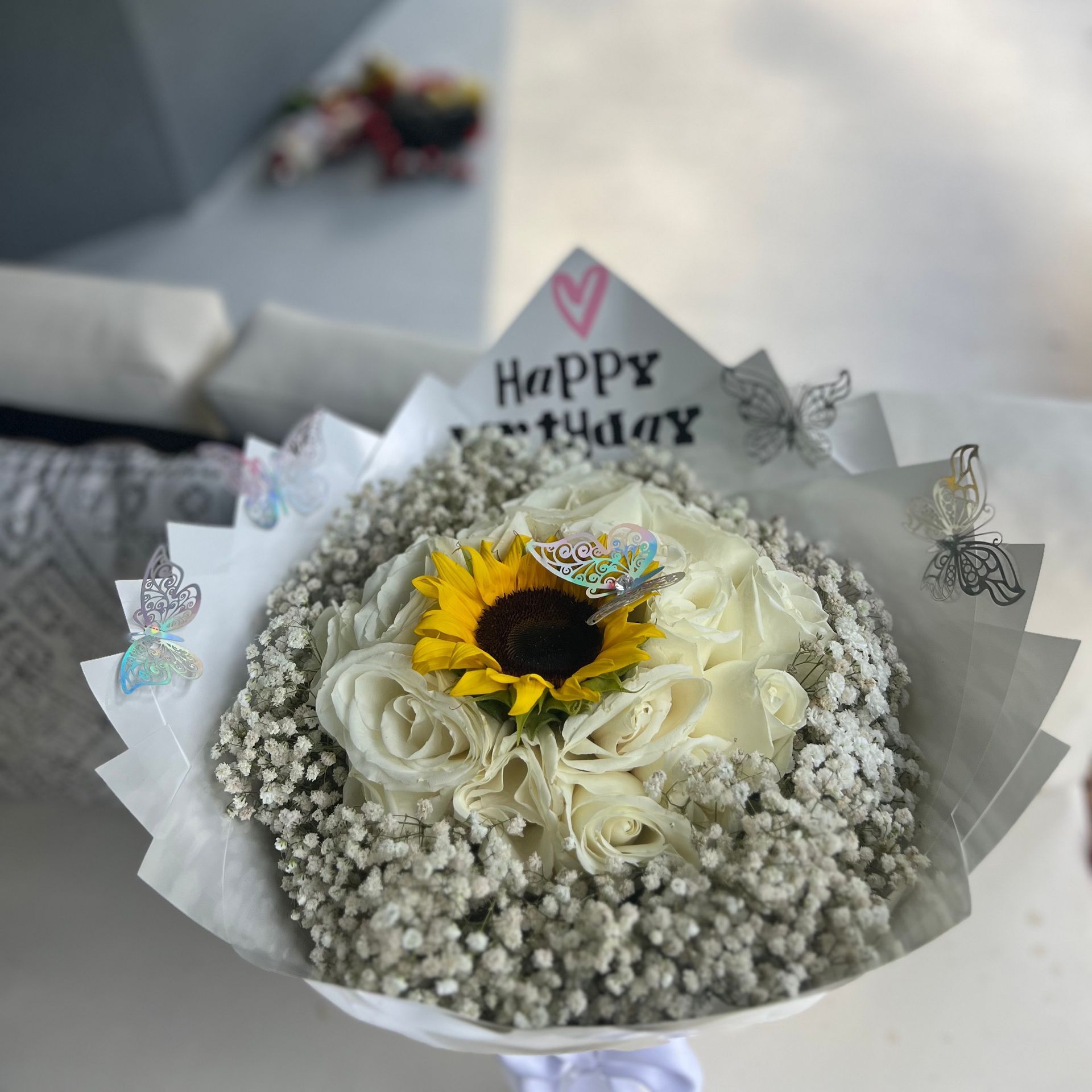 A bouquet of flowers with a card that says happy birthday