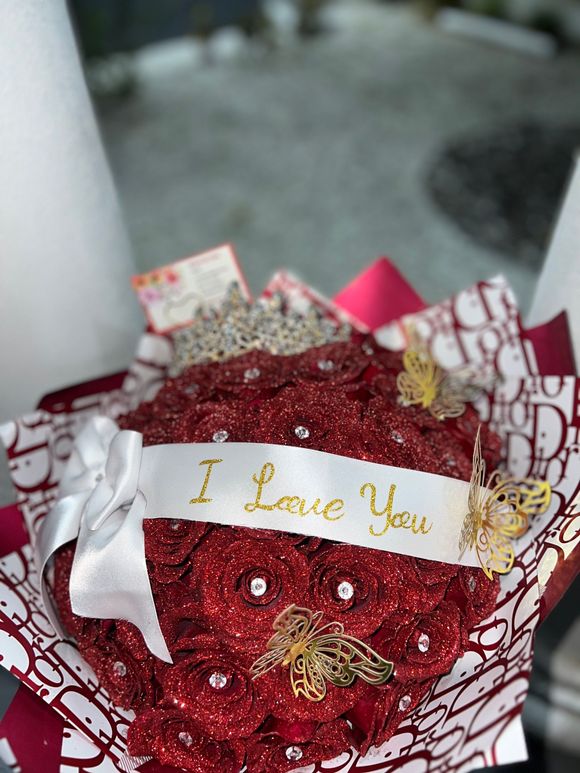 A bouquet of red roses with a ribbon that says `` i love you ''