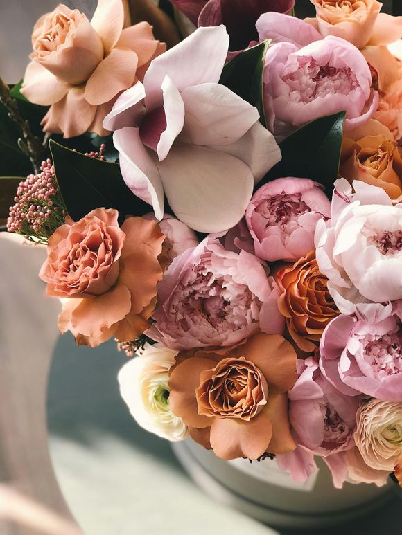 A vase filled with pink and orange flowers is sitting on a table.