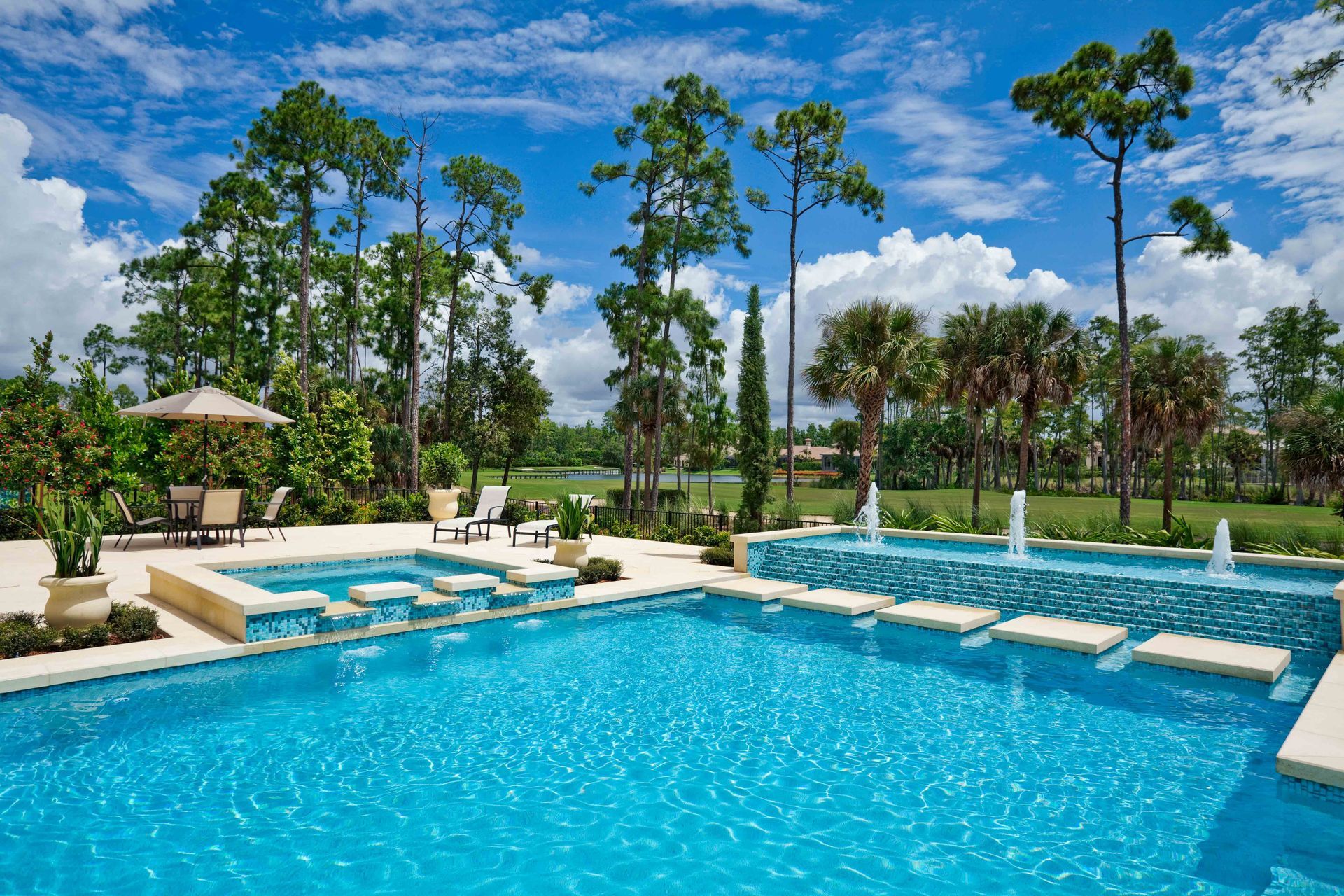 A large swimming pool surrounded by trees and a gazebo.