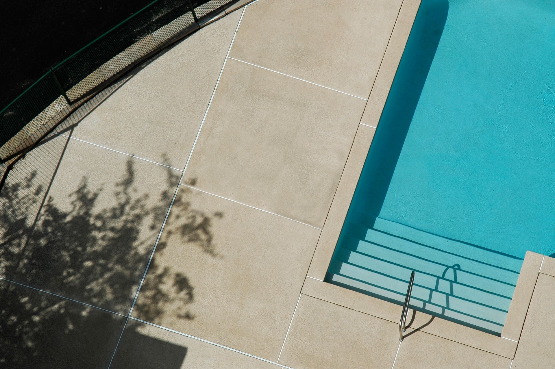 An aerial view of a swimming pool with stairs leading to it.