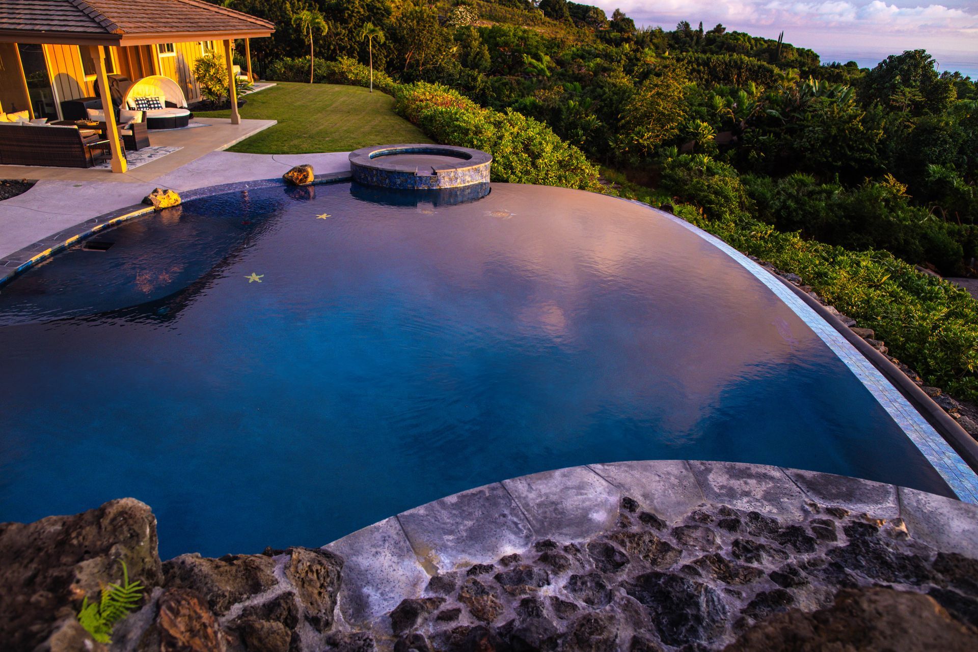 A large swimming pool is surrounded by rocks and trees.